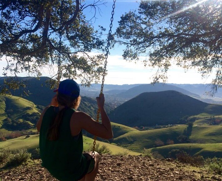 Girl on the Serenity Swing looking out over San Luis Obispo