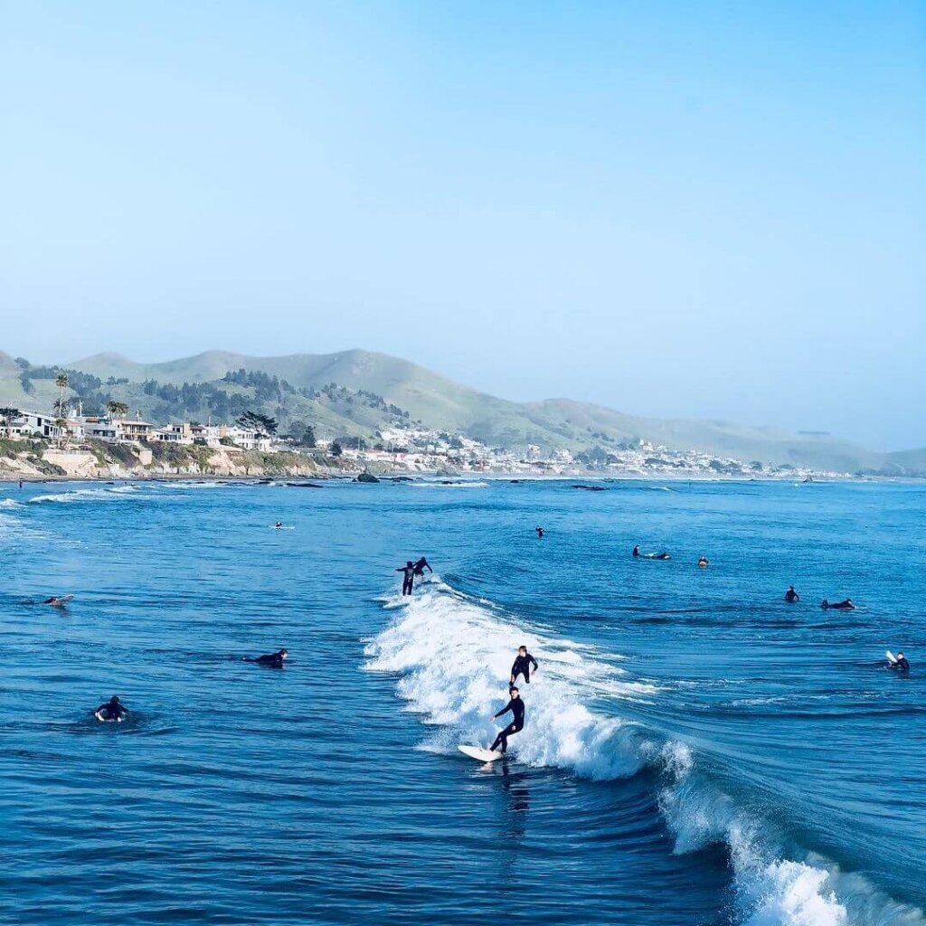 Surfers surf some waves at Cayucos State Beach