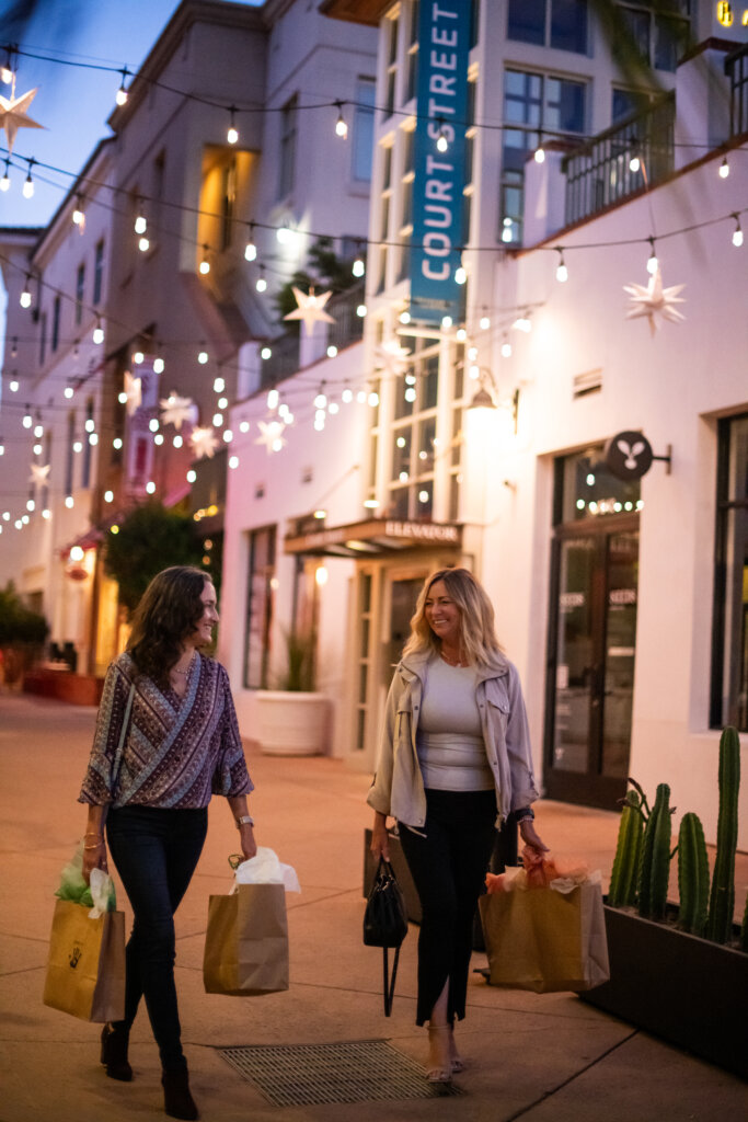 two-ladies-shopping-holding-bags-at-night