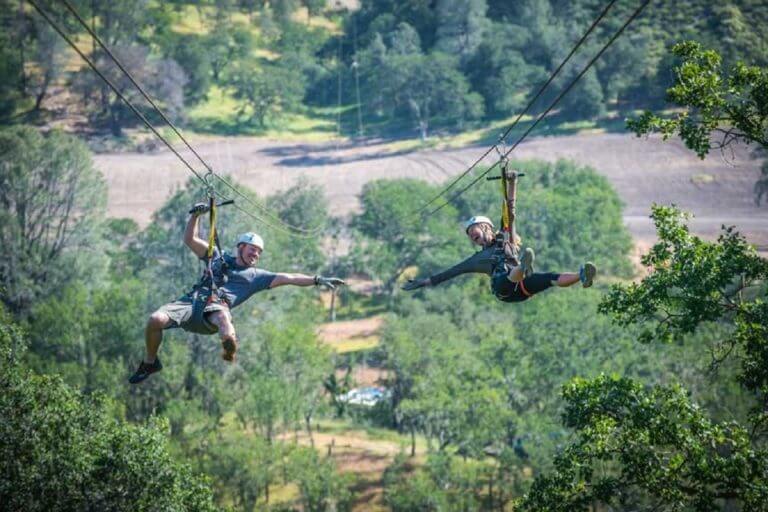 two people zip lining outdoors
