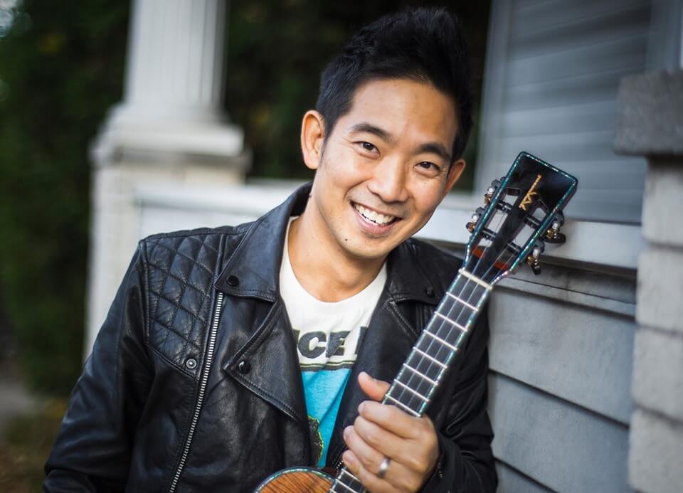 Guitarist, Jake Shimabukuro smiling with his guitar.