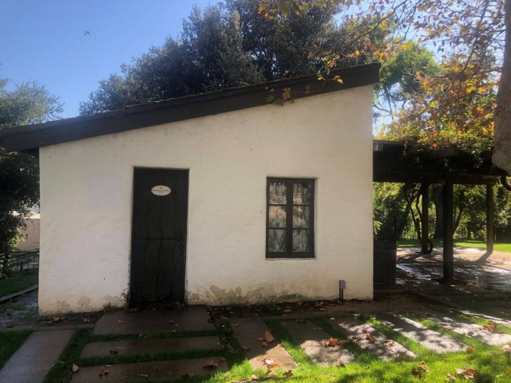 The front of the Murry Adobe, a small, white, historic home in San Luis Obispo, California.