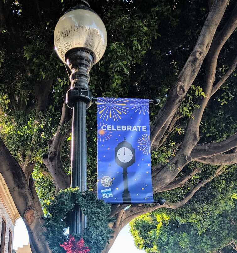 Downtown San Luis Obispo street light banner that says, "celebrate."