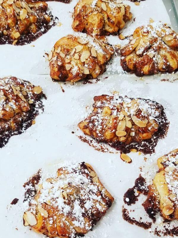 Flaky Pastries on parchment paper with a dusting of powdered sugar Joliene Bakery in San Luis Obispo.