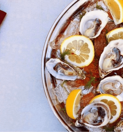 Oysters on ice with lemon wheels from above.