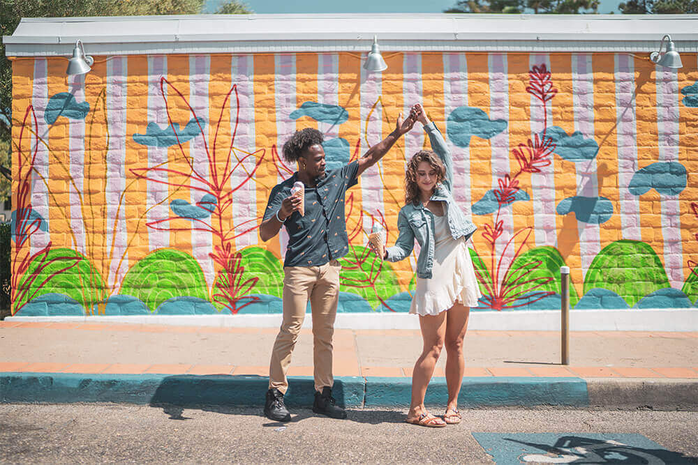 couple dances in front of a mural in downtown SLO