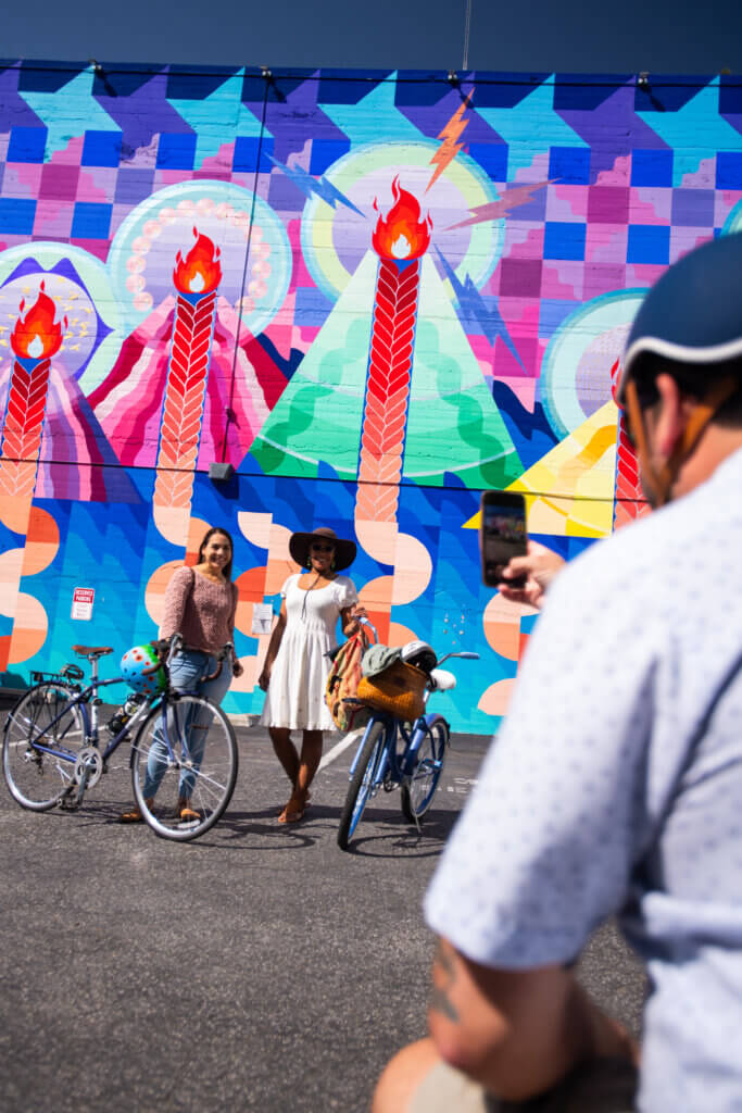 SLO bicyclists getting photo in front of colorful mural