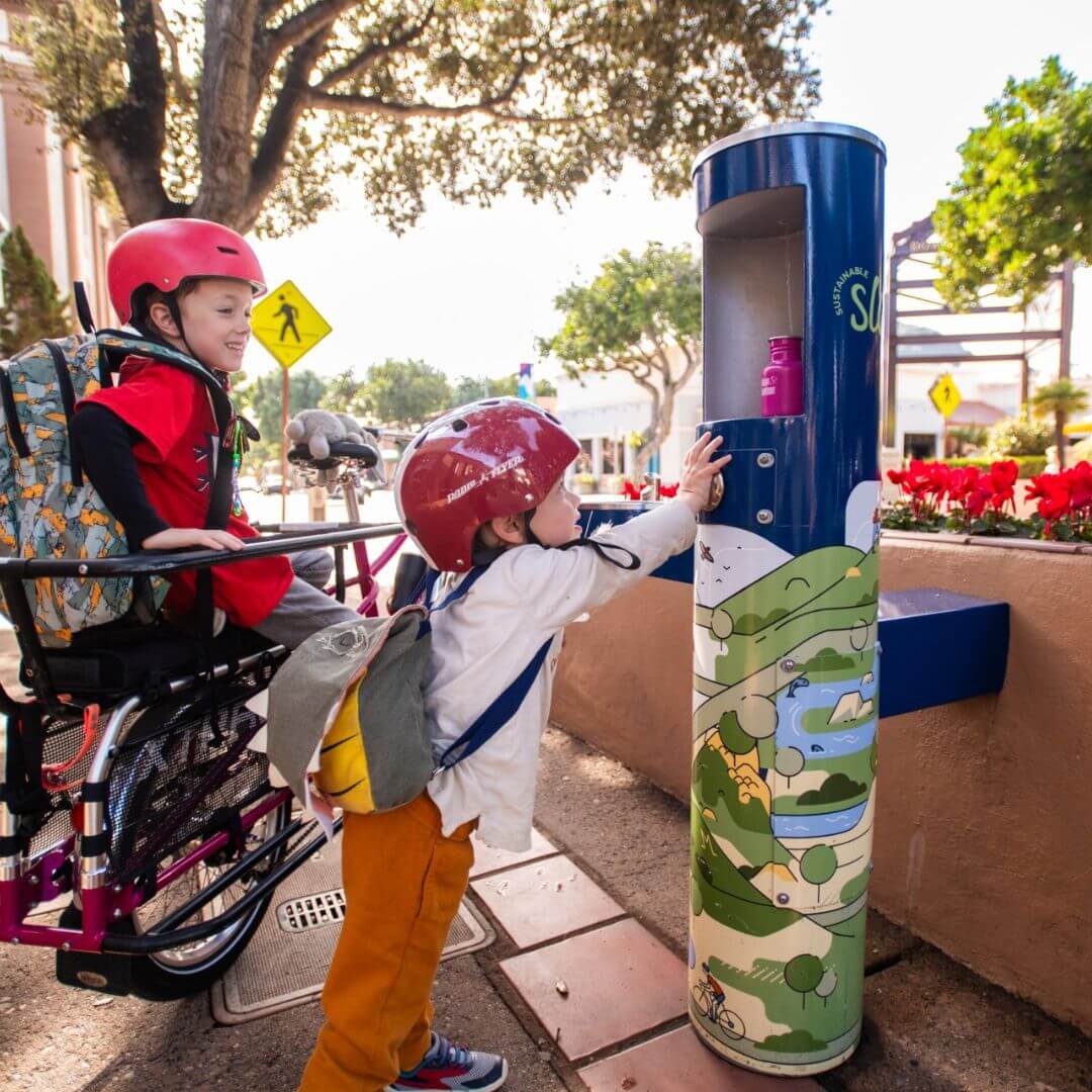 Child filling up water bottle at refilling station